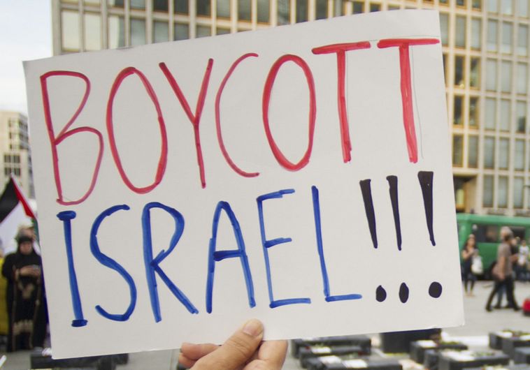 A woman holds a sign which reads
