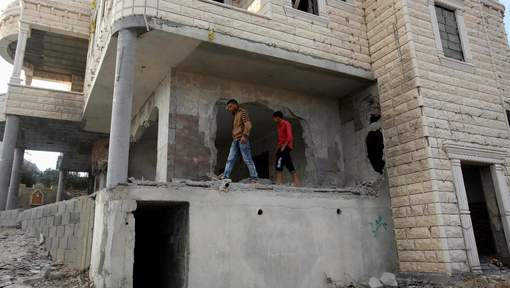 Relatives check the damage to the family house of Palestinian assailant Mohammad Tarayra after it was partially blown up by Israeli troops in the West Bank village of Bani Naem
