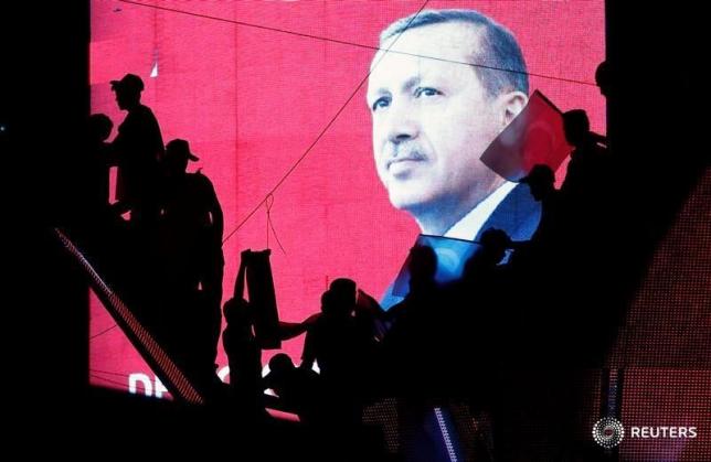 Turkish Supporters are silhouetted against a screan showing President Tayyip Erdogan during a pro-government demonstration in Ankara