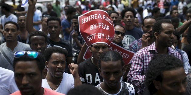 A migrant from Eritrea displays a placard near Tel Aviv