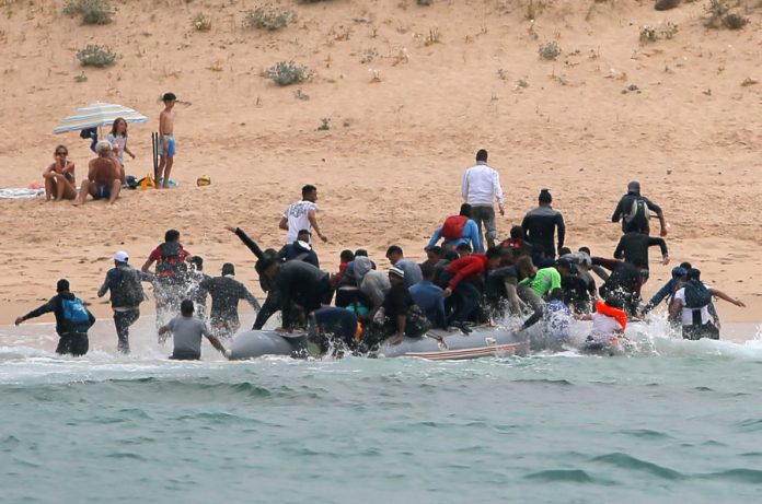 Migrants disembark from a dinghy at