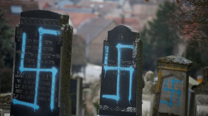 Graves desecrated with swastikas are seen in the Jewish cemetery in Quatzenheim