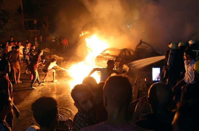 People extinguish a fire from a blast outside the National Cancer Institute, Cairo
