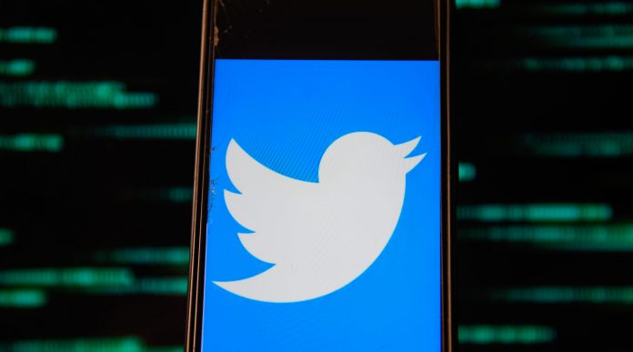 In this photo illustration a Twitter logo is seen displayed