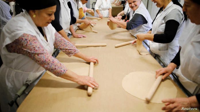 Ultra-Orthodox Jewish women prepare matza in Komemiyut
