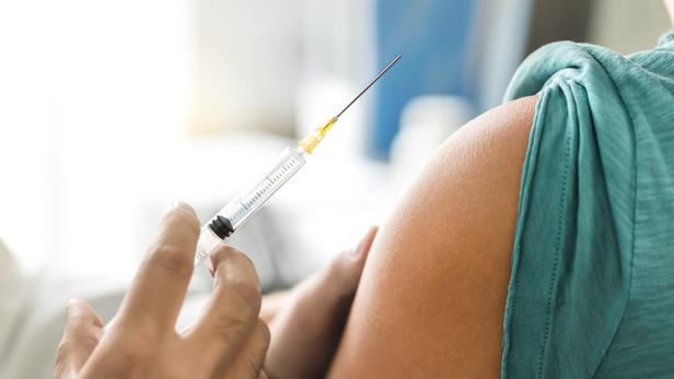 Vaccine or flu shot in injection needle. Doctor working with patient's arm. Physician or nurse giving vaccination and immunity to virus, influenza or HPV with syringe. Appointment with medical expert.