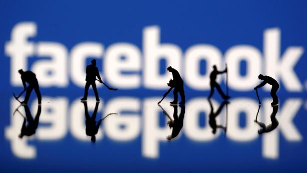 FILE PHOTO: Figurines are seen in front of the Facebook logo in this illustration