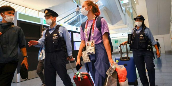 Belarusian athlete Krystsina Tsimanouskaya is escorted by police officers at Haneda international airport in Tokyo, Japan